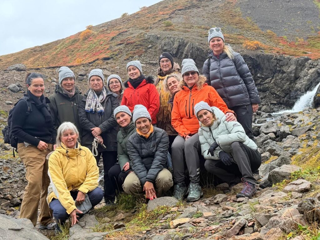 Gruppe in Outdoorkleidung und Mützen vor einer Schlucht in Island
