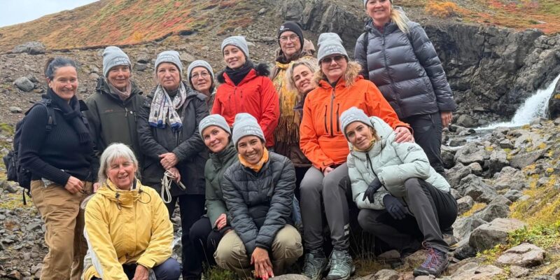Gruppe in Outdoorkleidung und Mützen vor einer Schlucht in Island