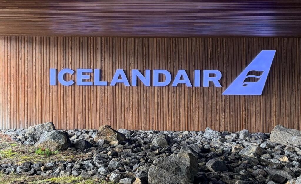 Icelandair-Schriftzug an einer Holzwand über Lavasteinen