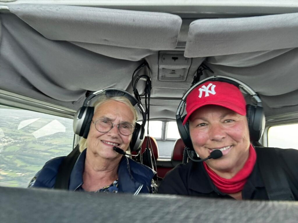 Fluglehrerin und Trainee mit Headsets im Cockpit während des Flugs